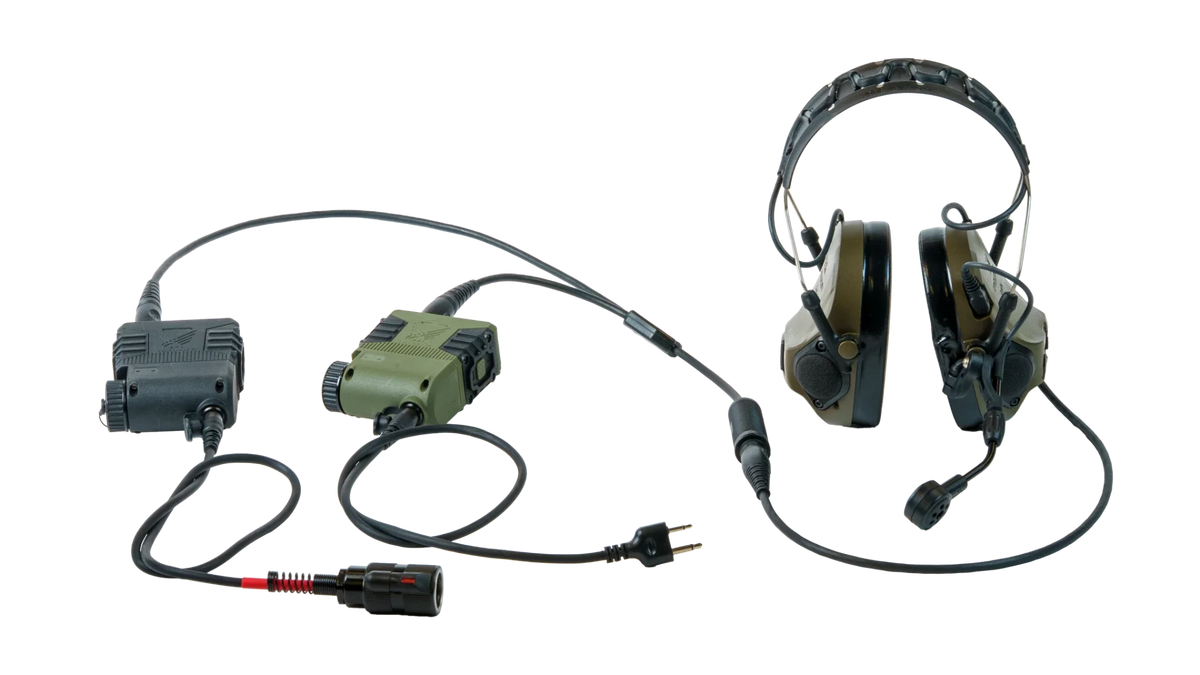 Dual Com Adapter setup: one headset connected through the Dual Com cable to two PTTs, black and green, each with its own radio lead
