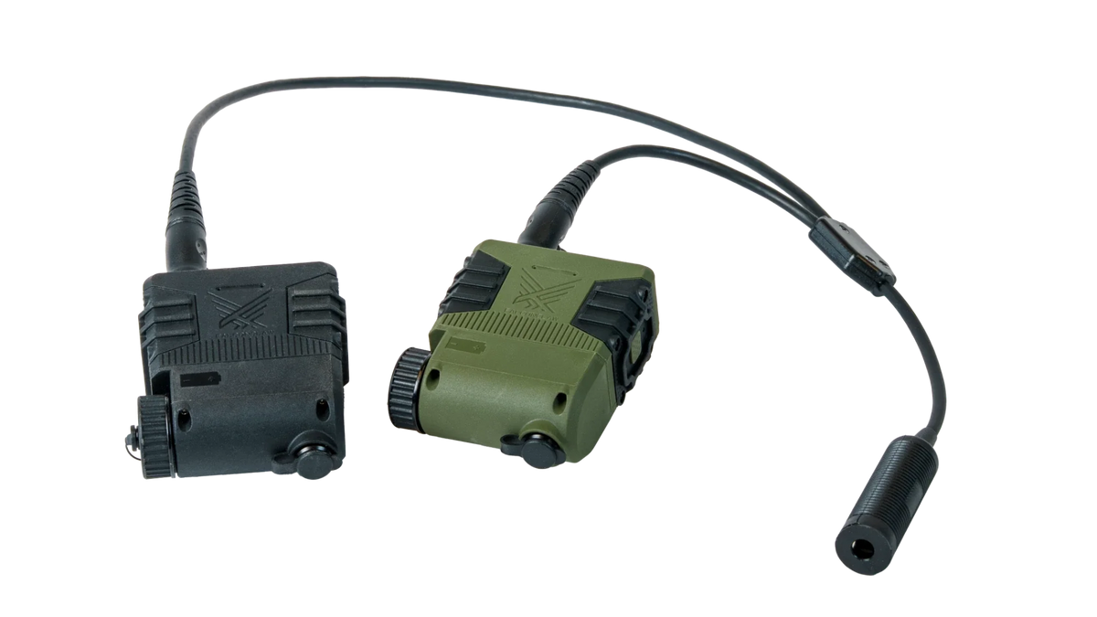 Dual Com Adapter cable plugged into two PTTs, black and green, with the single headset-side socket